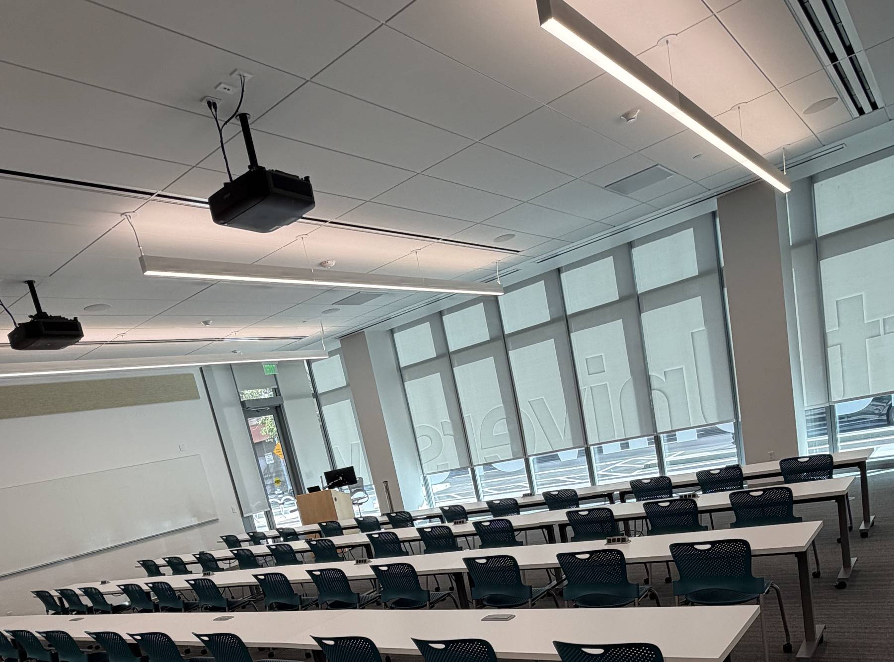 Rows of desks and task chairs installed and aligned in a college classroom