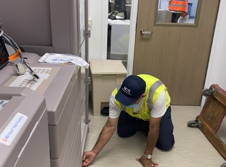 NCS crew member setting medical equipment in place at a healthcare facility