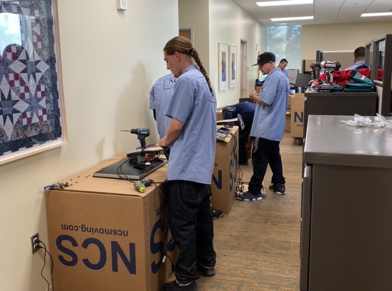 NCS crew reconnecting workstation monitors during an office relocation